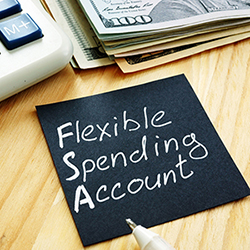 Flexible spending account FSA sign on a black piece of paper.